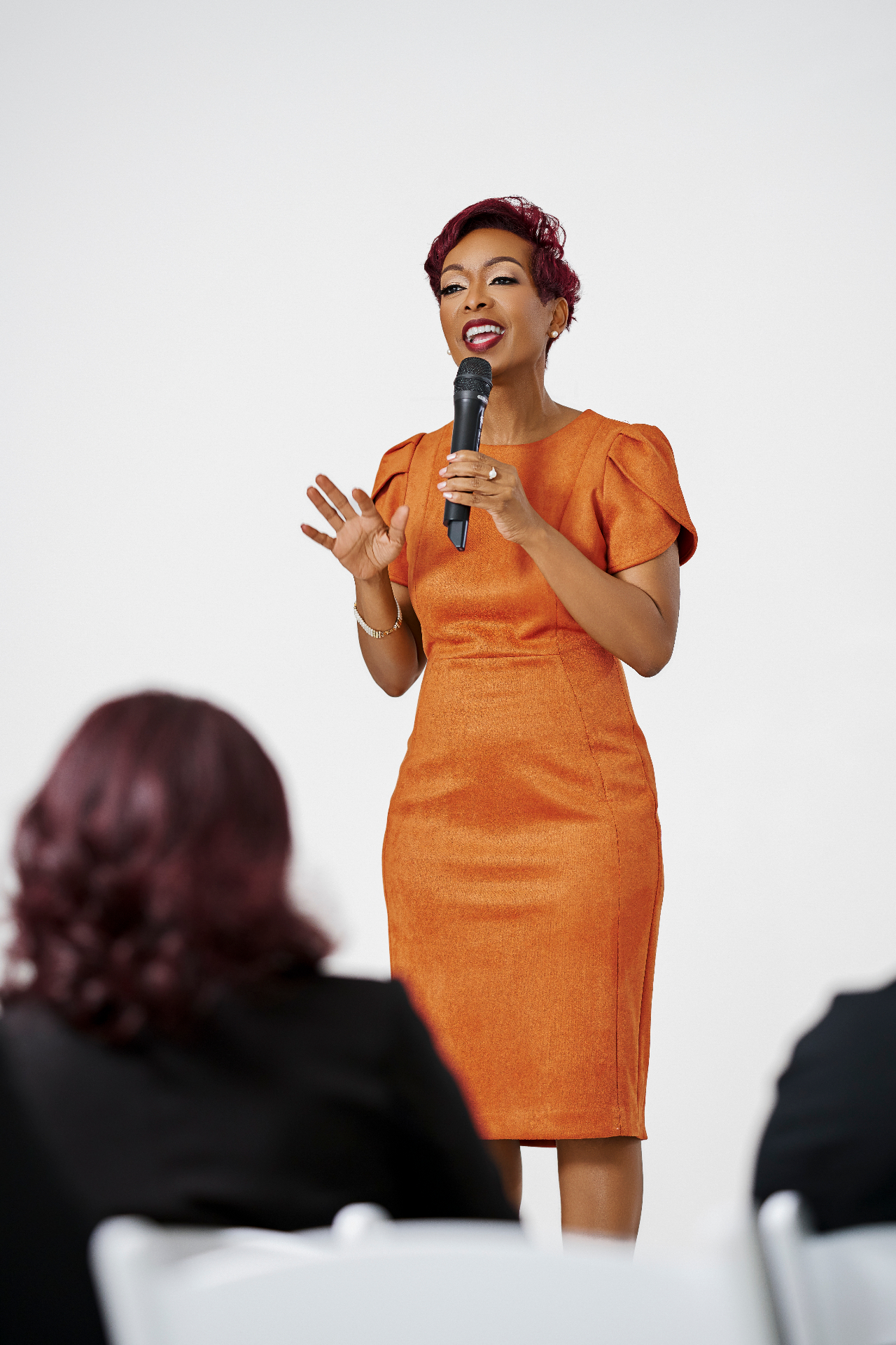 Dr. Shana speaking with a microphone in front of an audience